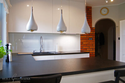 Meble na wymiar w kuchni z połączeniem koloru czarnego, białego i cegły